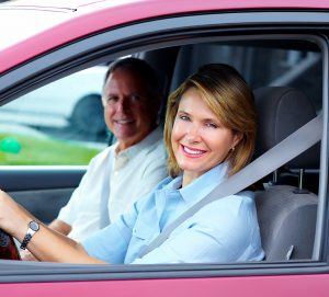 Smiling woman in red car. Title Loans Dallas