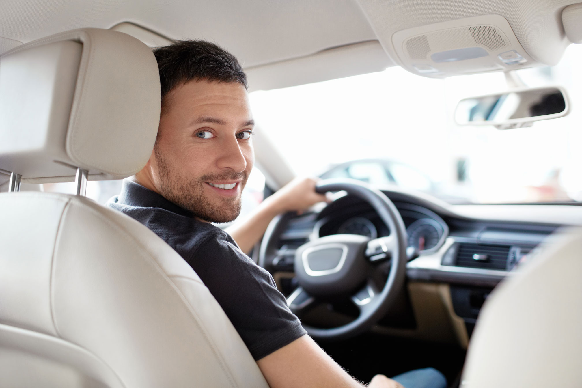 Man smiling in the driver's seat. 