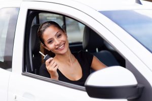 Girl in a car with car keys. Title Loans