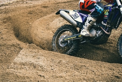 A man riding a motorcycle down a dirt road